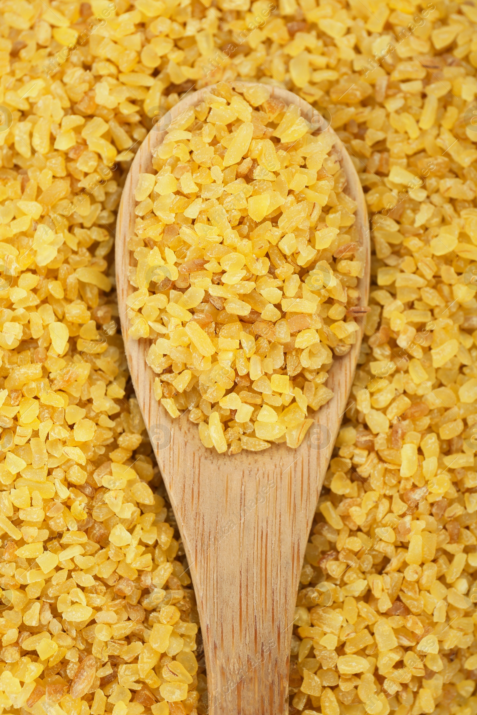 Photo of Spoon on pile of uncooked bulgur, top view