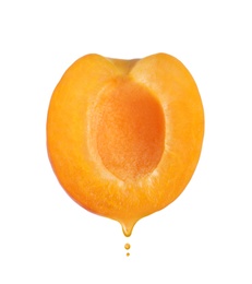 Image of Apricot oil dripping from fresh fruit half on white background