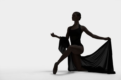 Image of Beautiful ballerina with veil dancing on white background, space for text. Dark silhouette of dancer