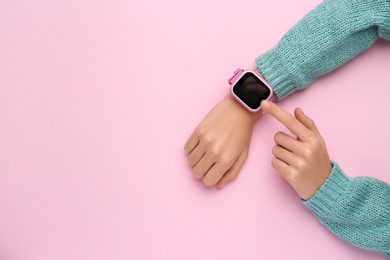 Girl with stylish smart watch on pink background, top view. Space for text