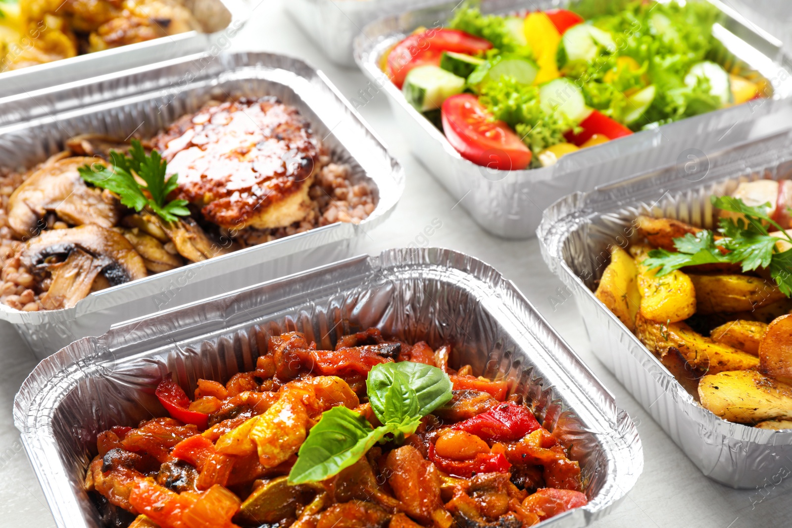 Photo of Lunchboxes on white wooden table, closeup. Healthy food delivery