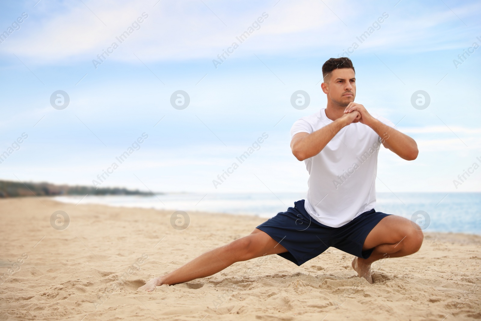 Photo of Muscular man doing exercise on beach, space for text. Body training