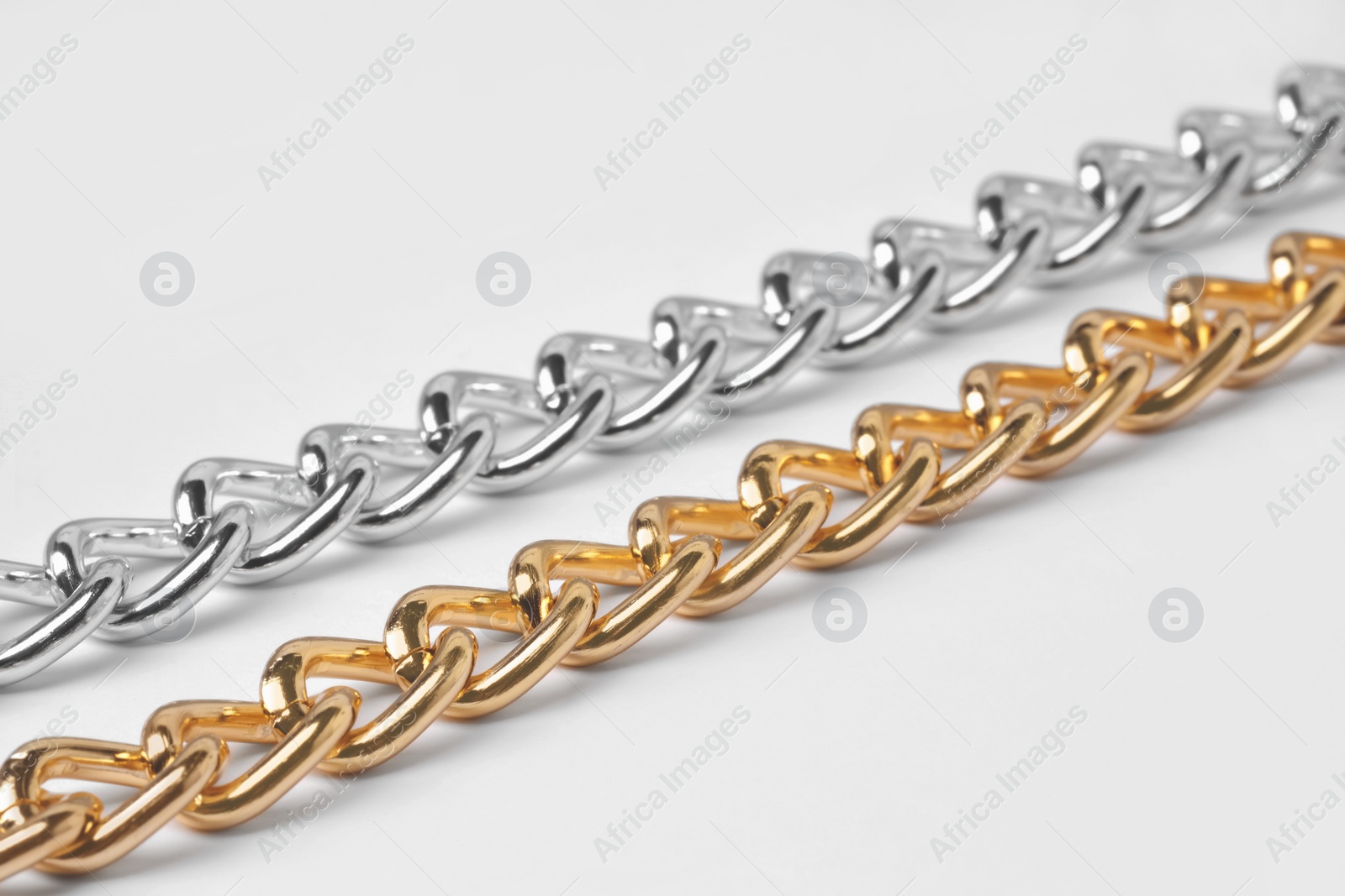 Photo of Metal chains isolated on white, closeup. Luxury jewelry