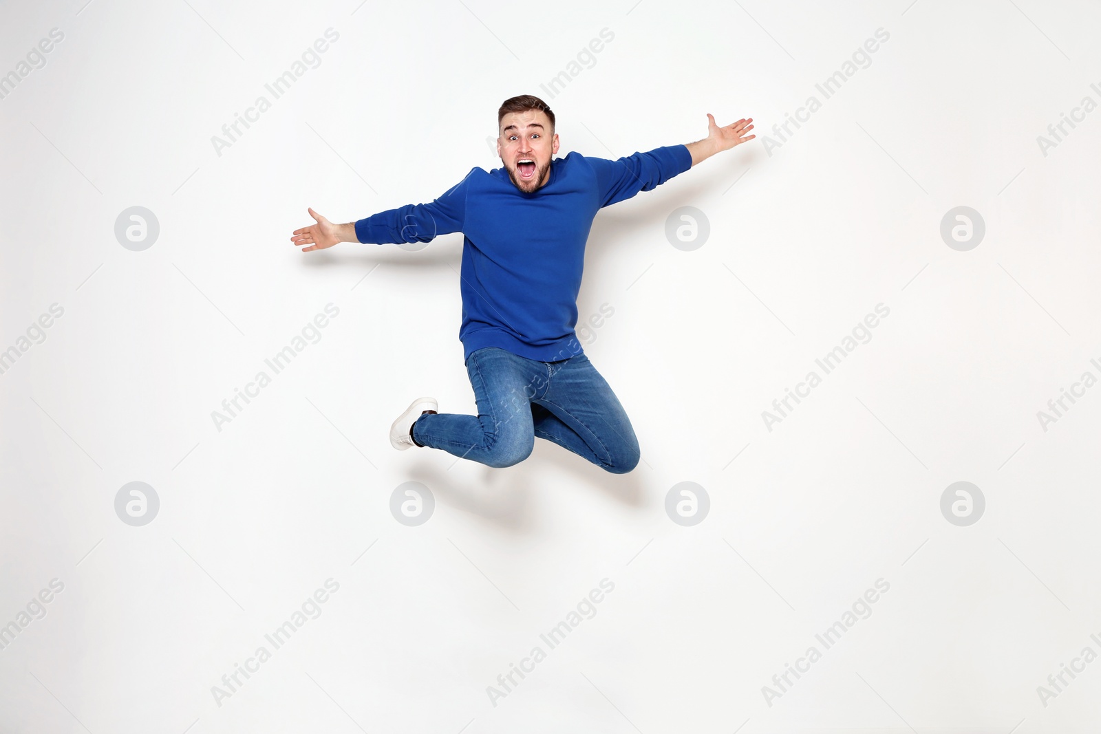 Photo of Full length portrait of handsome man jumping on white background