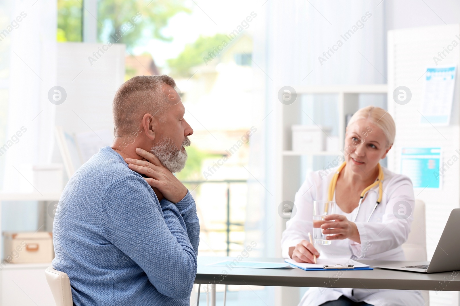 Photo of Coughing mature man visiting doctor at clinic