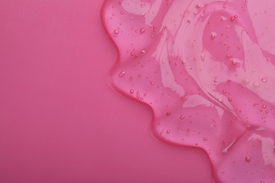 Photo of Pure transparent cosmetic gel on pink background, top view