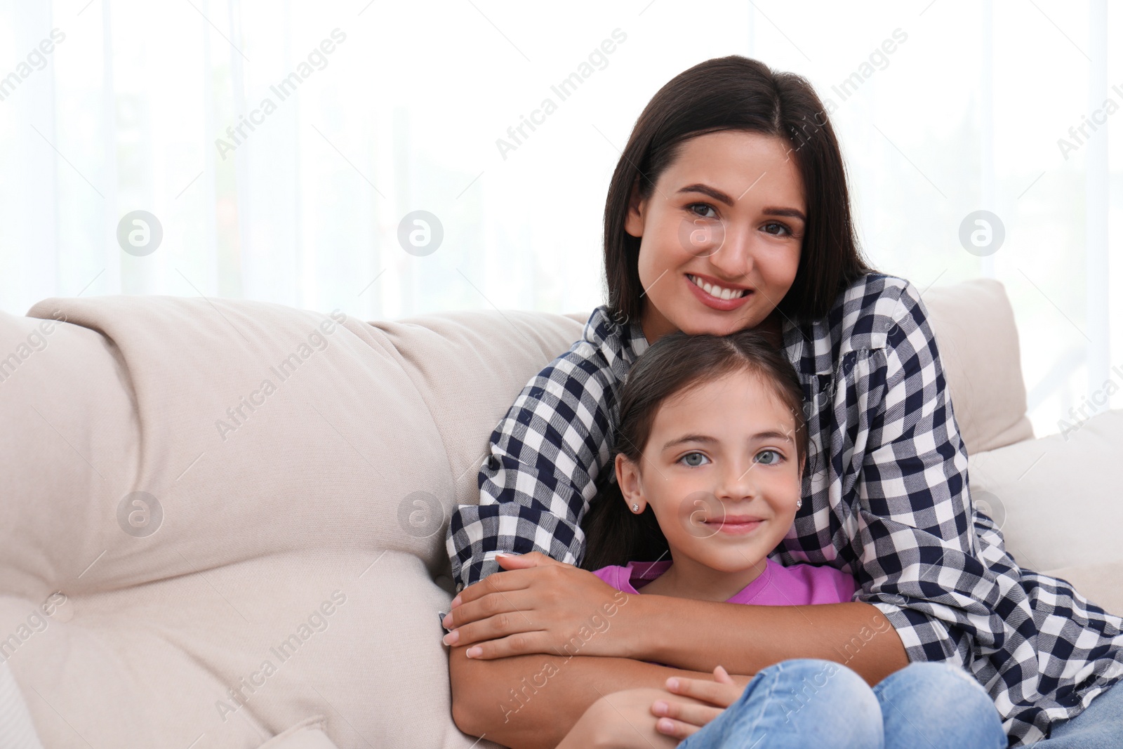 Photo of Portrait of happy mother and daughter on sofa at home. Single parenting