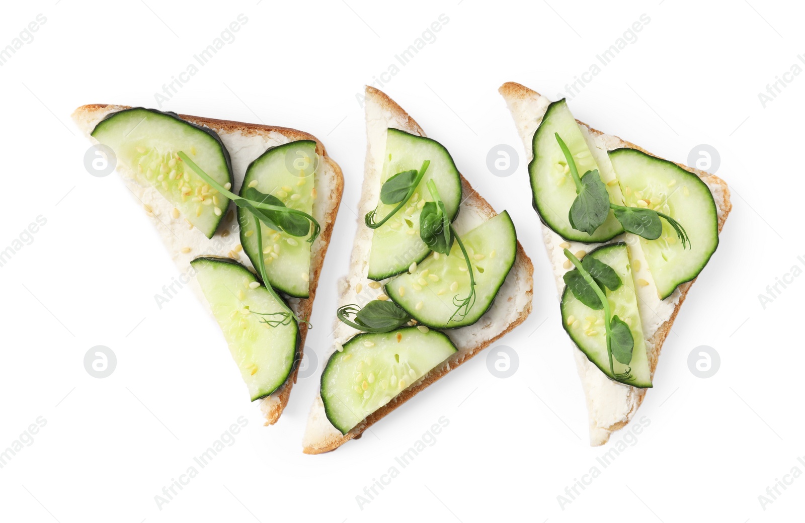 Photo of Tasty cucumber sandwiches with sesame seeds and pea microgreens on white background, top view