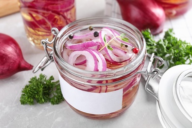 Jar of pickled onions on marble table