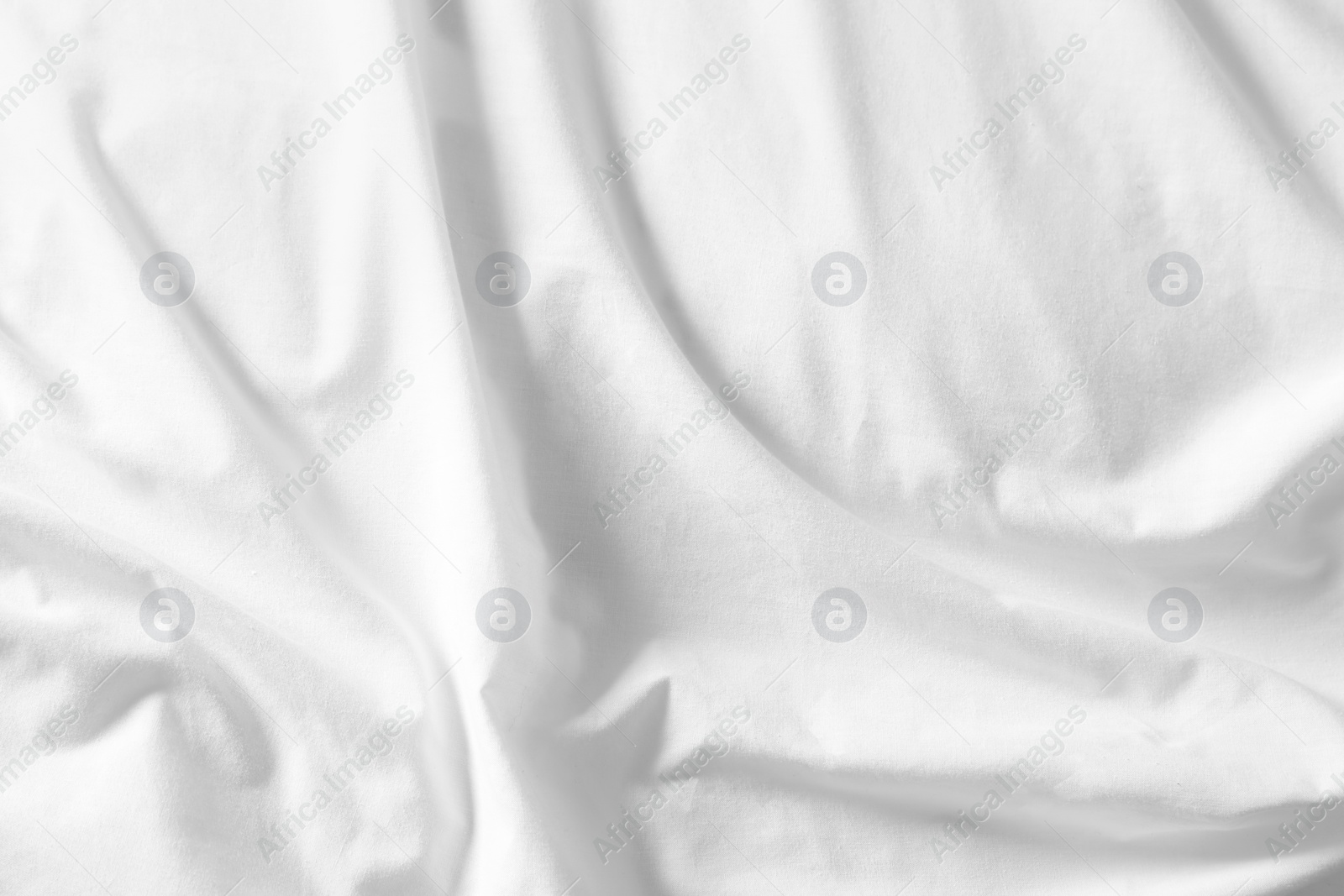 Photo of Crumpled white fabric as background, top view