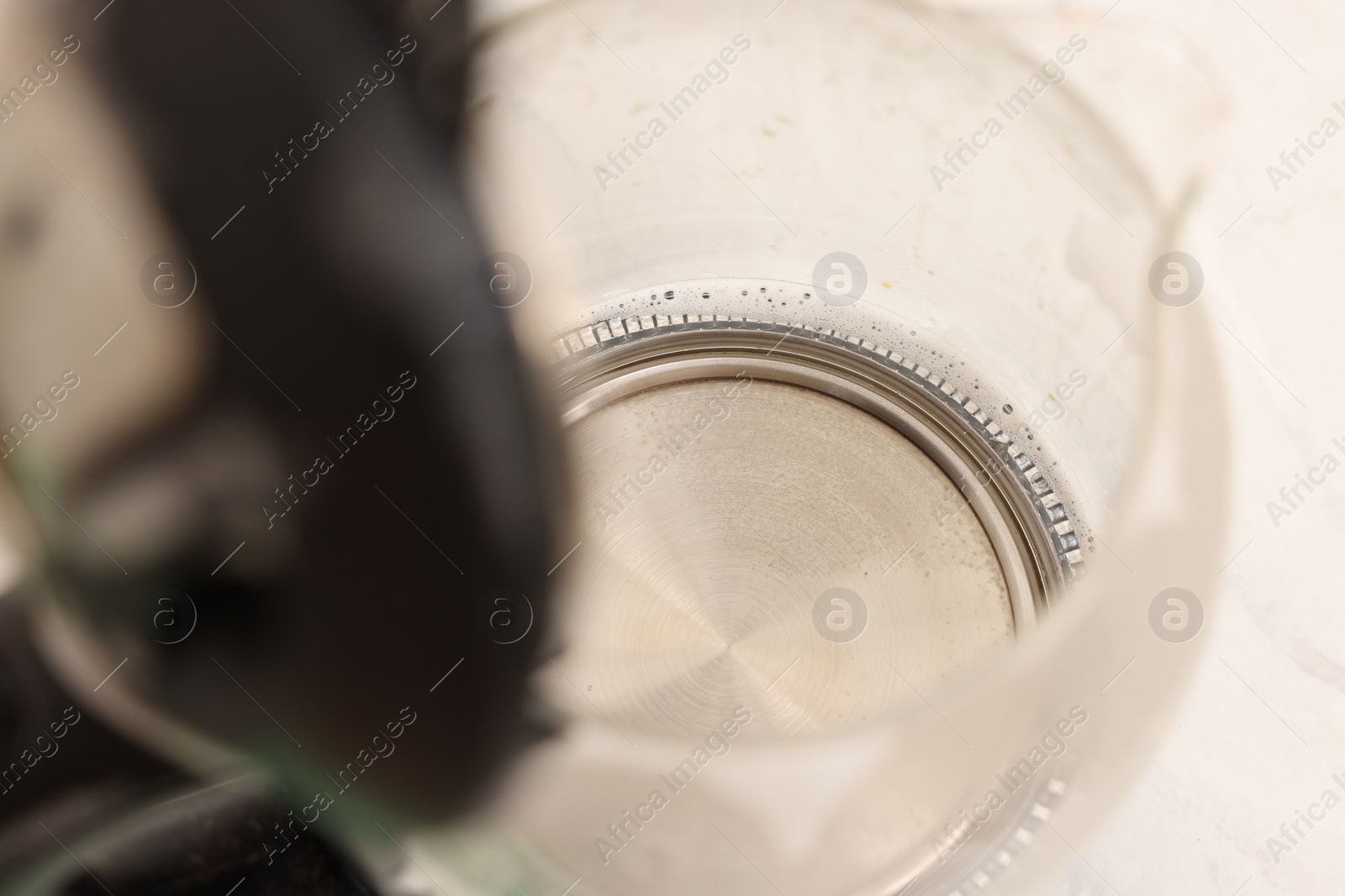 Photo of Cleaning electric kettle. Appliance with vinegar and baking soda on table, closeup