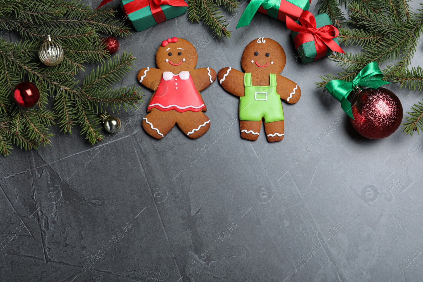 Photo of Flat lay composition with gingerbread couple on black table, space for text