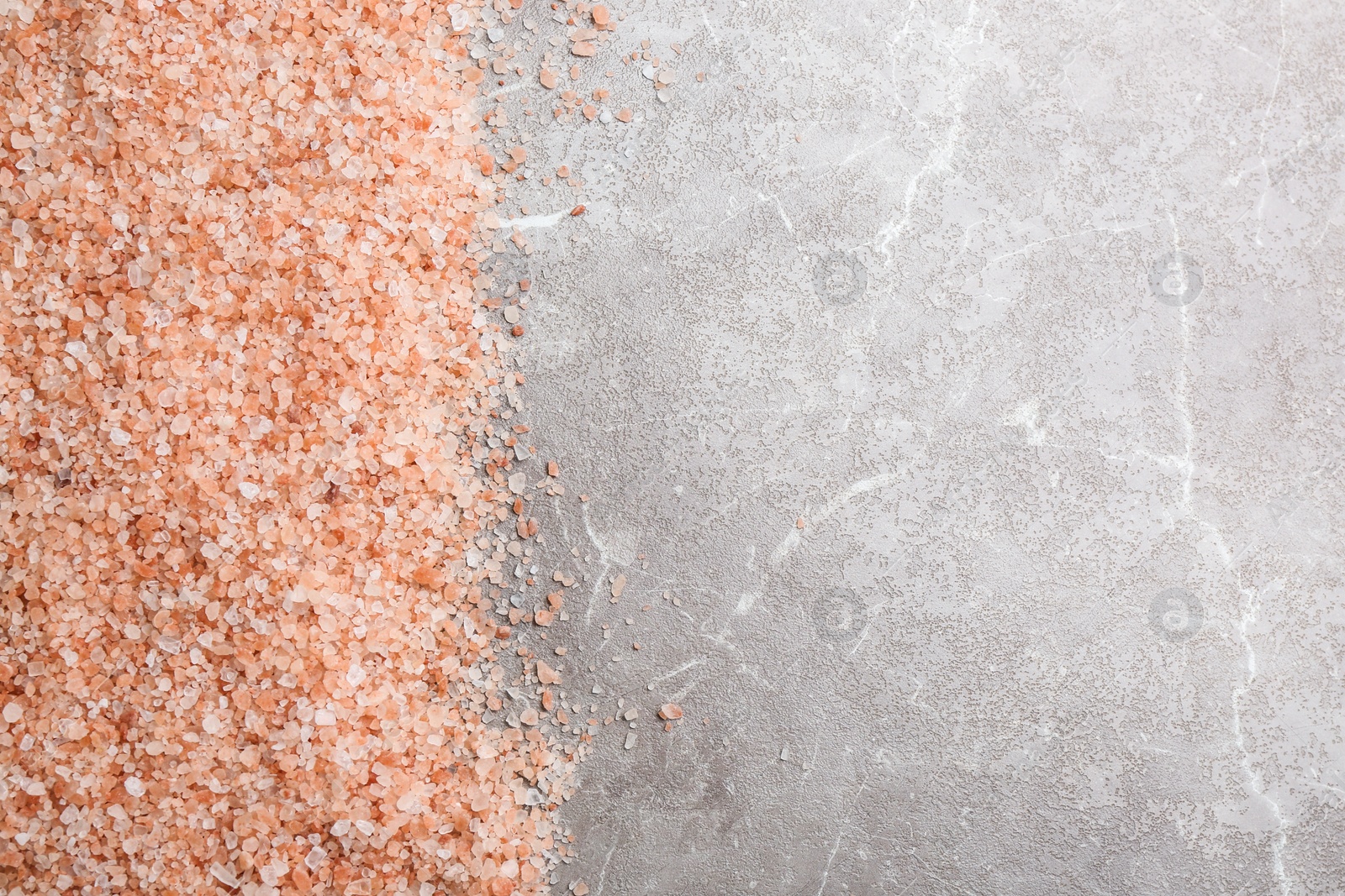 Photo of Pink himalayan salt on grey table, flat lay. Space for text