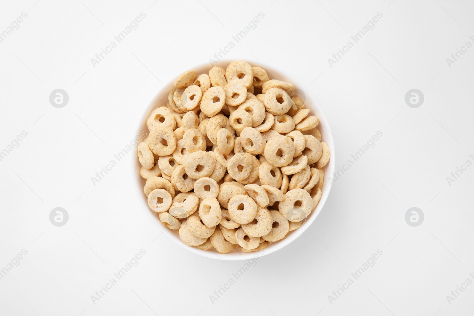 Photo of Tasty cereal rings in bowl on white table, top view