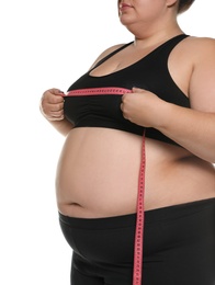Photo of Overweight woman measuring her chest with tape on white background, closeup