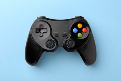 Wireless game controller on light blue background, top view