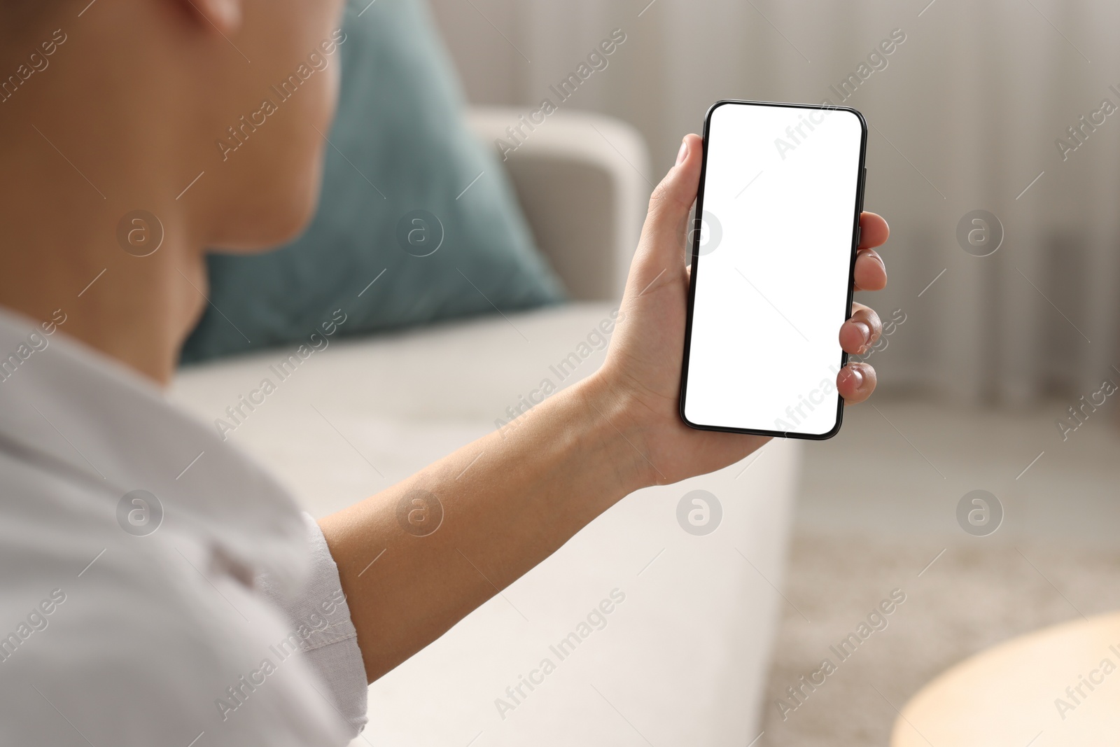 Photo of Man using smartphone with blank screen indoors, closeup. Mockup for design