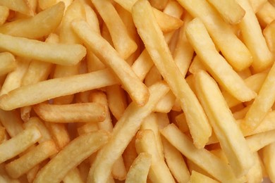 Many delicious French fry pieces as background