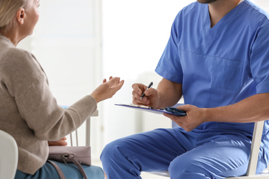 Doctor consulting patient in his office at hospital, closeup