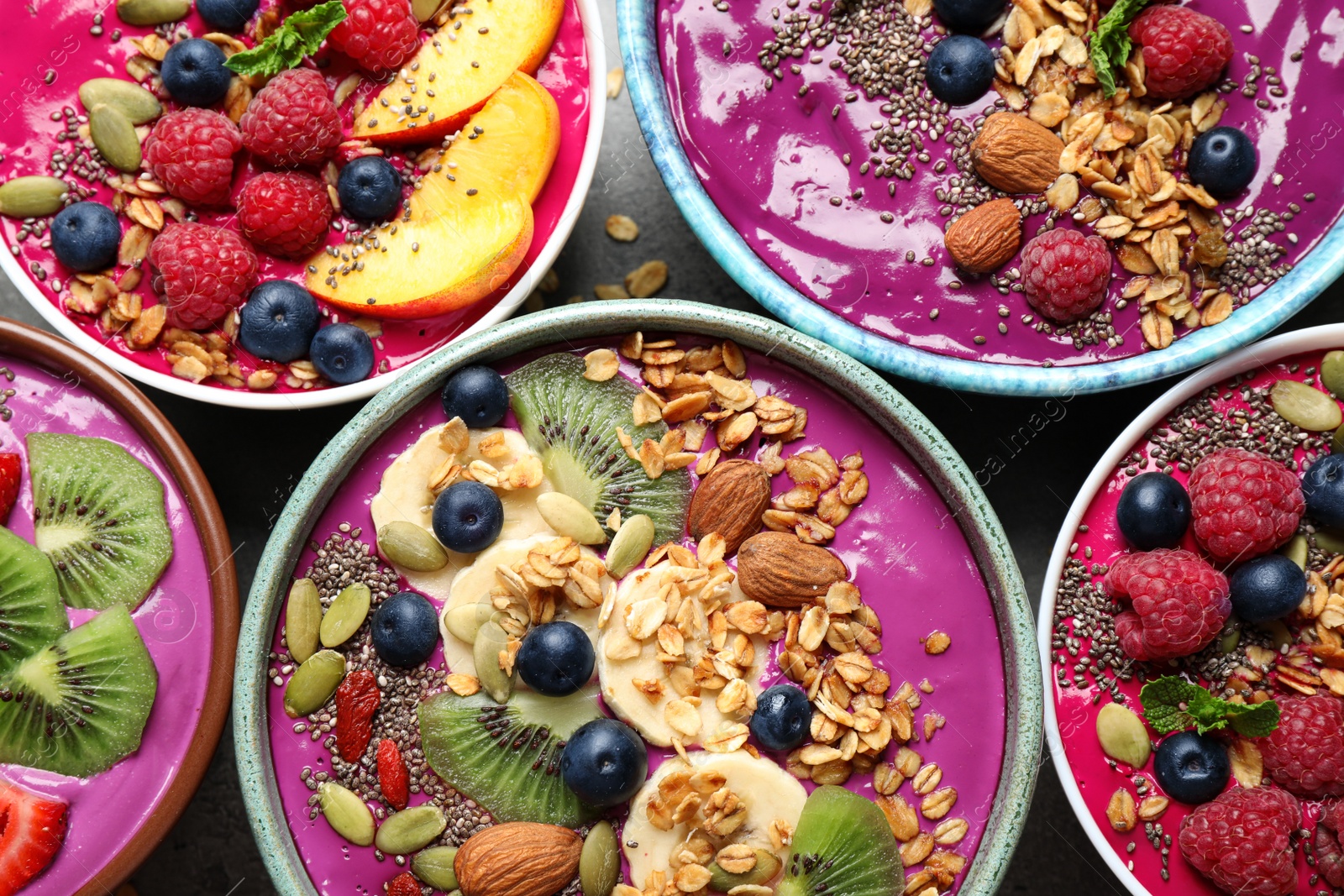 Image of Delicious acai smoothie with toppings in bowls on table, flat lay