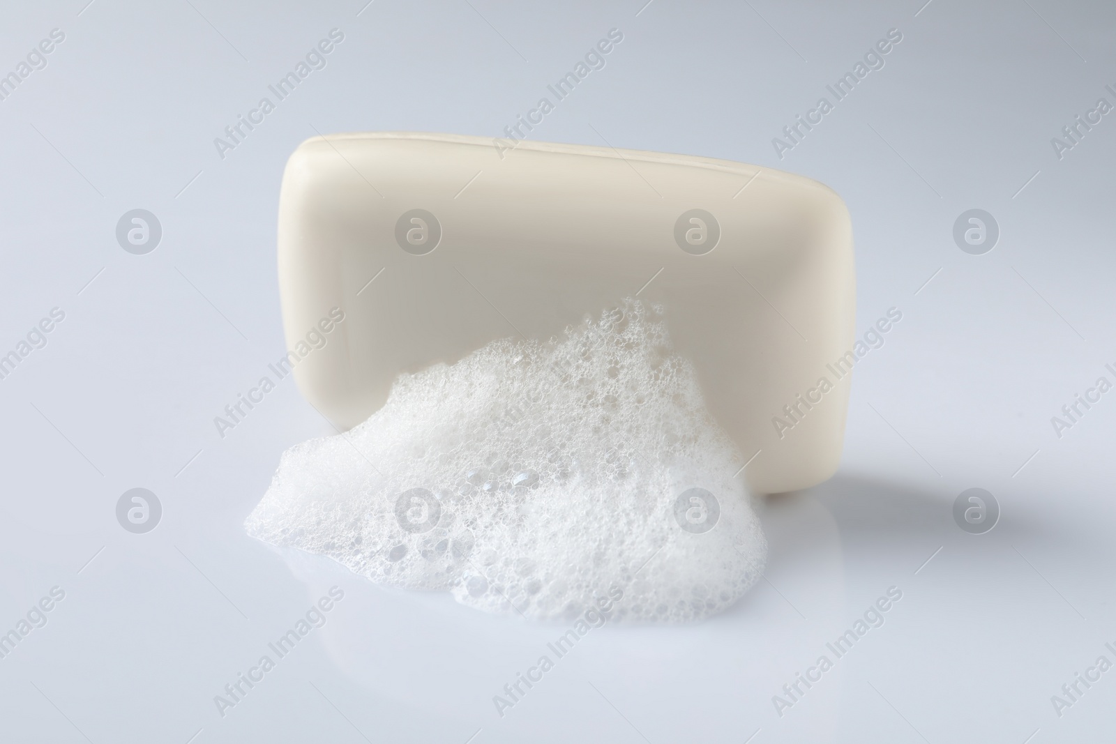 Photo of Soap with fluffy foam on white background