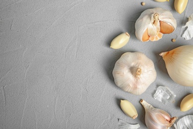Photo of Flat lay composition with garlic, onion and space for text on table