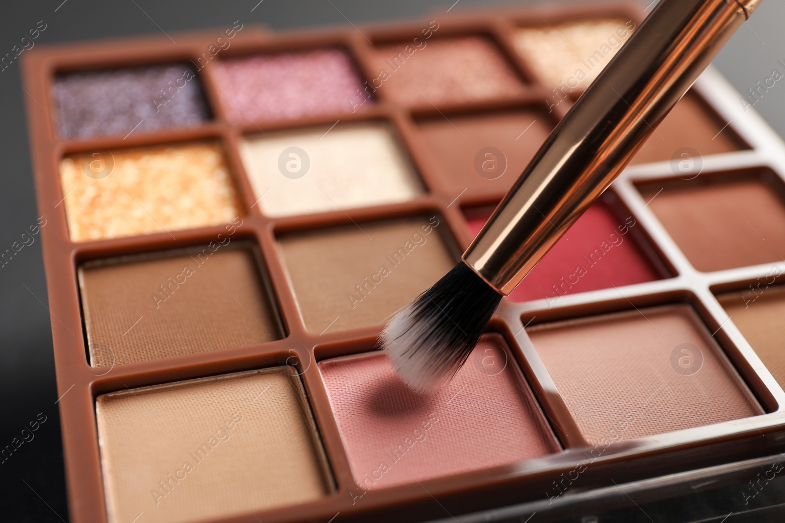 Photo of Colorful eyeshadow palette with brush, closeup view