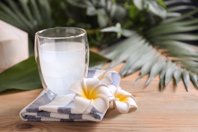 Photo of Glass with fresh coconut water on wooden table