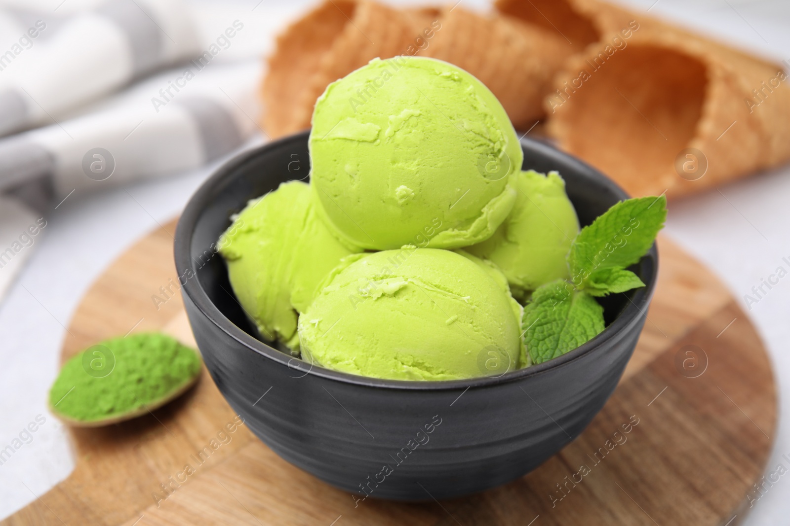 Photo of Tasty matcha ice cream in bowl on table, closeup