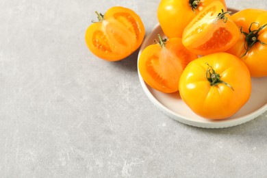 Photo of Fresh ripe yellow tomatoes on light table. Space for text