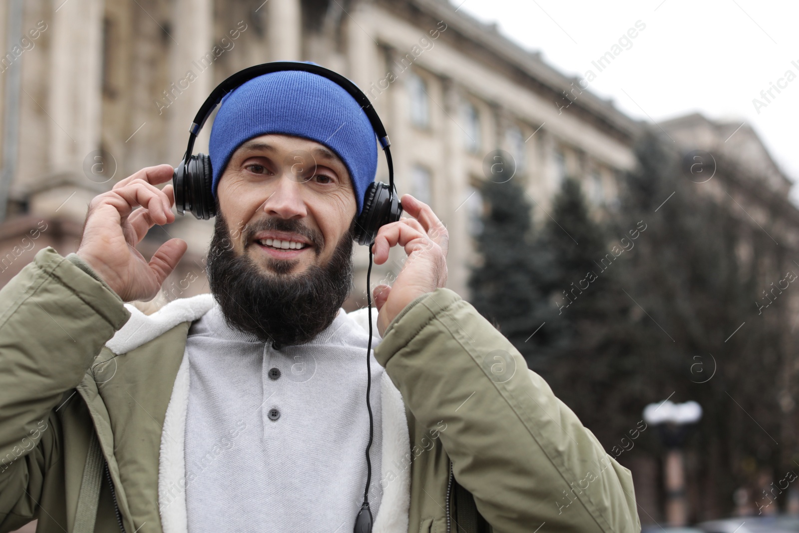 Photo of Mature man with headphones listening to music outdoors