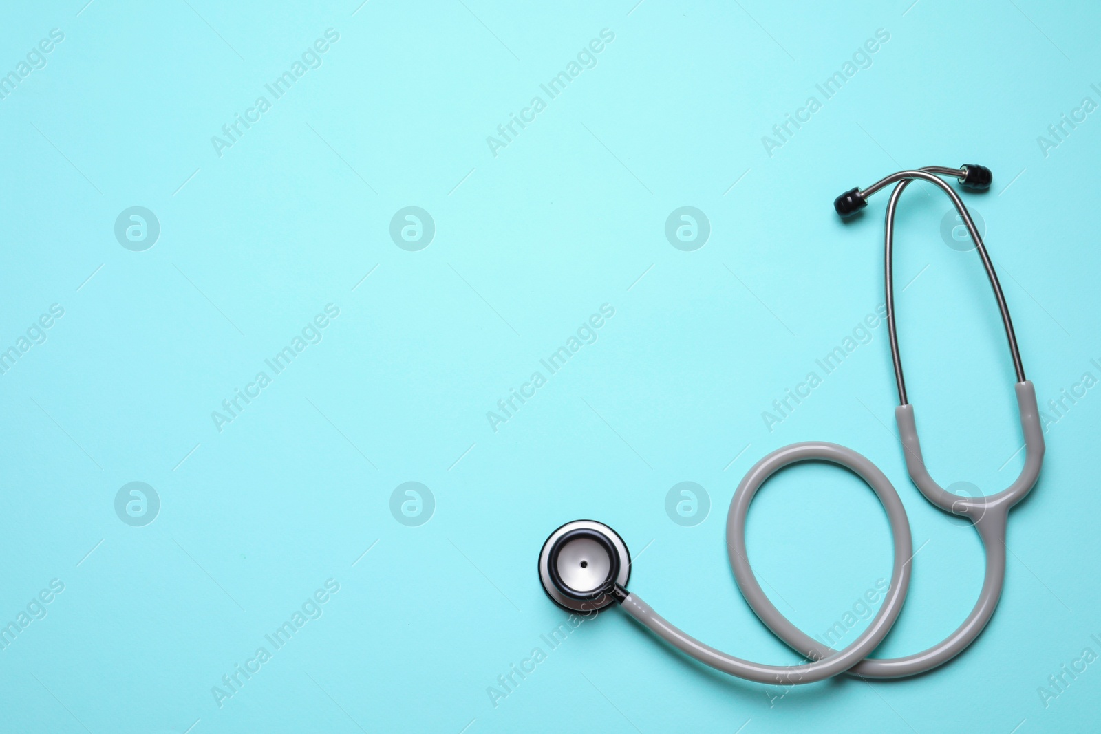 Photo of Stethoscope on light background, top view. Space for text