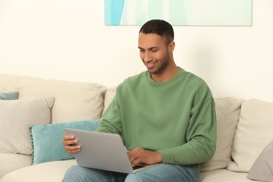 Photo of African American man working on laptop at home