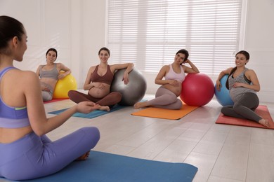 Trainer working with group of pregnant women in gym. Preparation for child birth