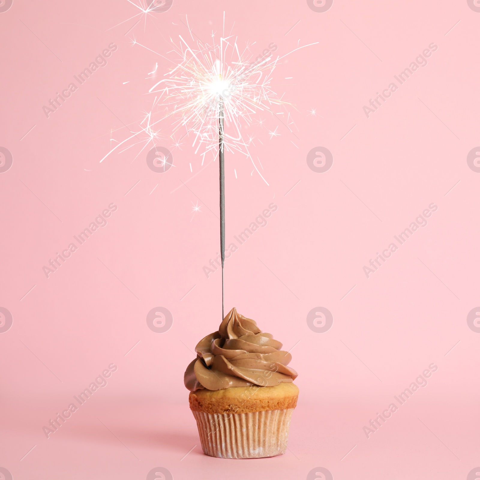 Image of Birthday cupcake with sparkler on pink background