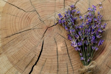 Bouquet of beautiful lavender flowers on wooden stump, top view. Space for text