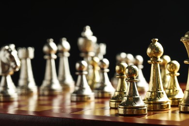 Photo of Chessboard with game pieces on black background