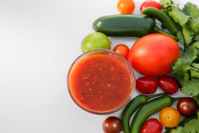 Bowl with delicious salsa sauce and ingredients on white background, flat lay. Space for text