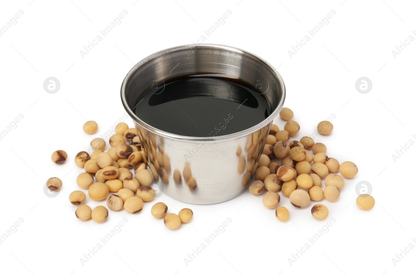 Photo of Tasty soy sauce in bowl and soybeans isolated on white