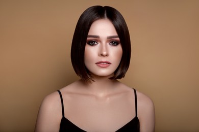 Image of Portrait of pretty young woman with short hair on pastel brown background