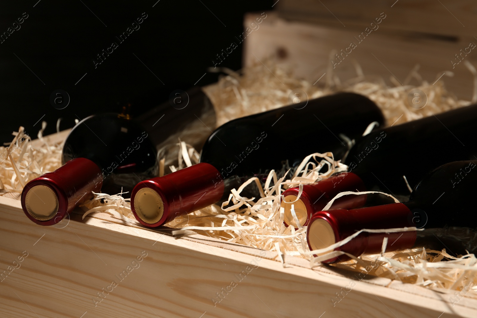 Photo of Wooden crate with bottles of wine, closeup