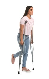 Photo of Young woman with axillary crutches on white background