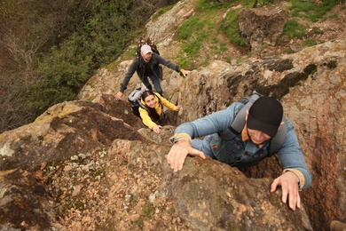 Group of hikers with backpacks climbing up mountains, above view