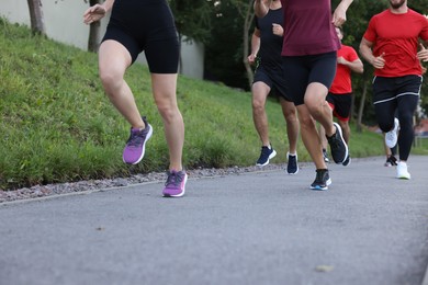 Photo of Group of people running outdoors, closeup view