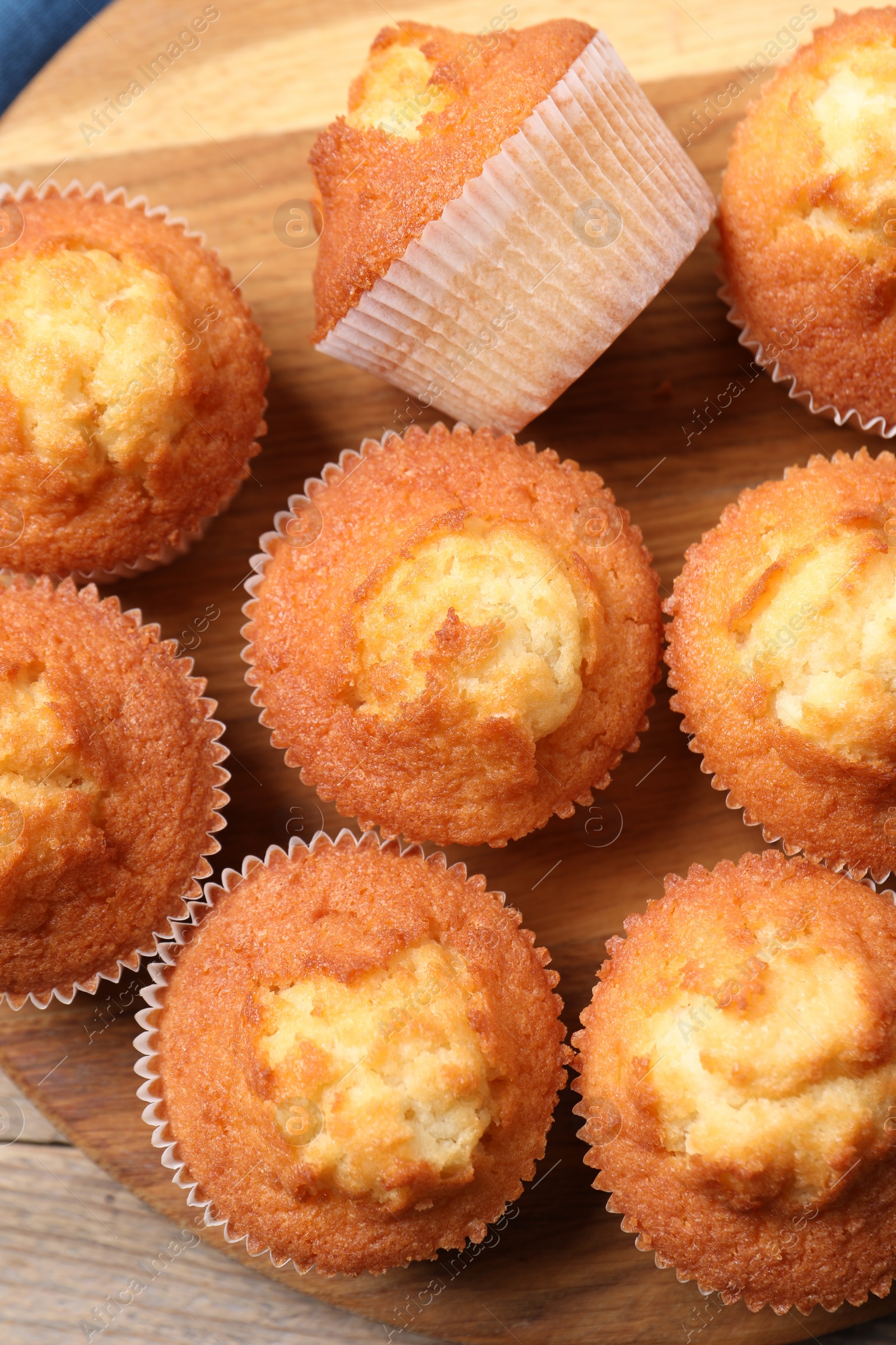 Photo of Delicious sweet muffins on wooden table, top view