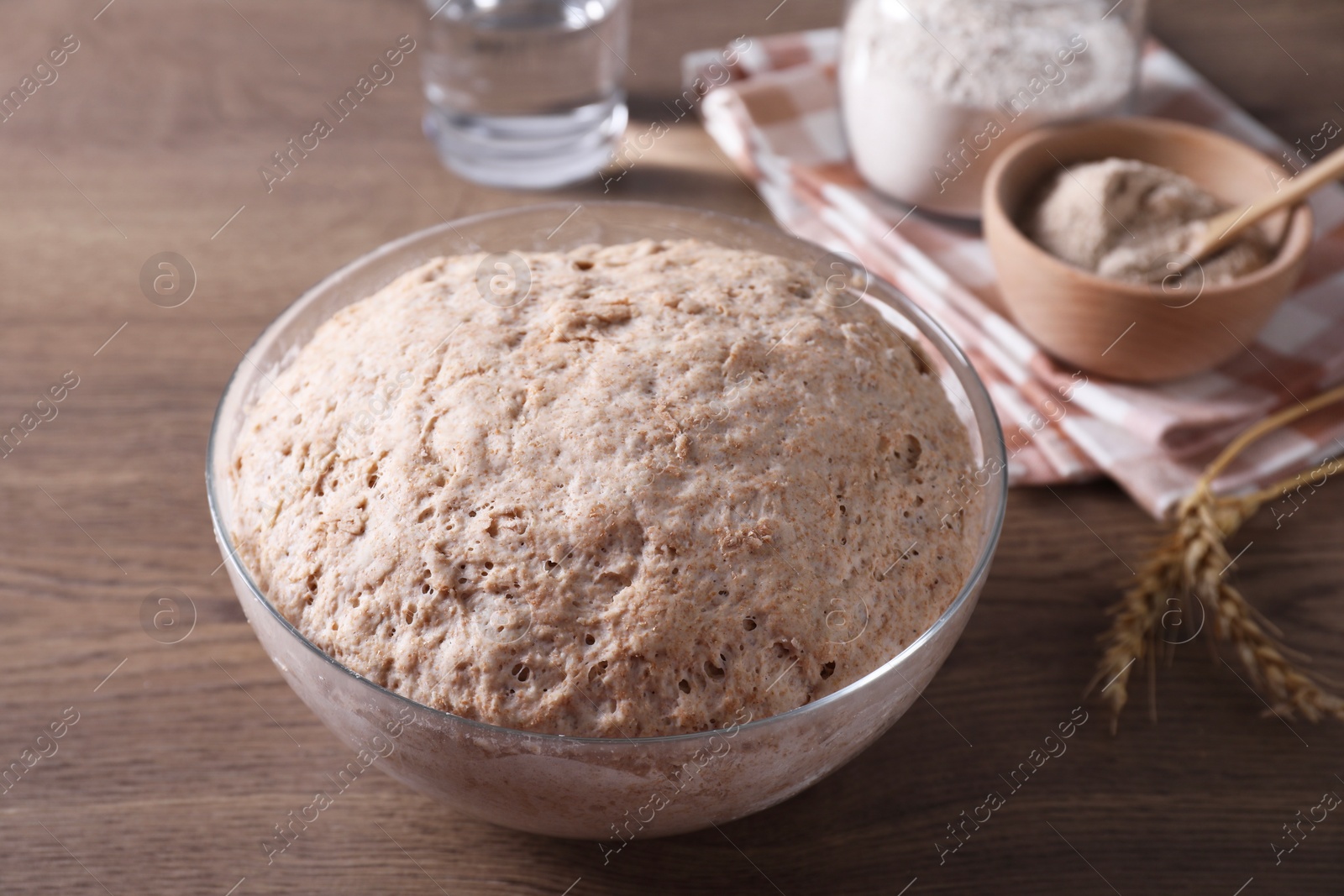 Photo of Fresh sourdough in bowl on wooden table, closeup