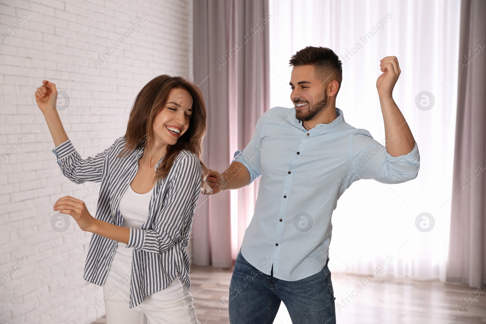 Photo of Lovely young couple dancing together at home