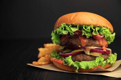 Photo of Tasty burger with vegetables, patties and lettuce served on wooden table, closeup. Space for text