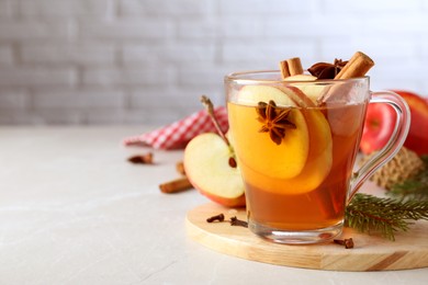 Photo of Aromatic hot mulled cider on light grey marble table. Space for text