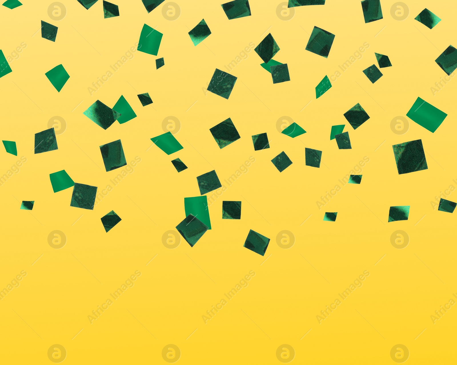 Image of Shiny green confetti falling on yellow background